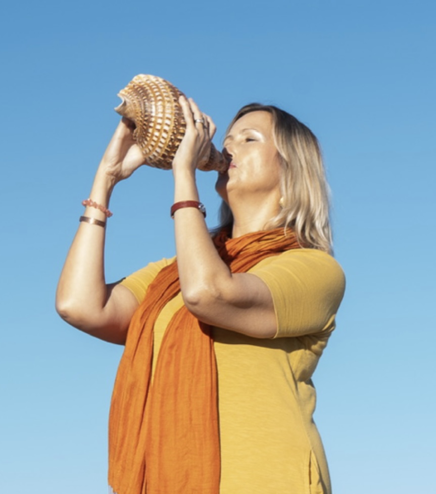 Em Ryan sounding a conch shell.